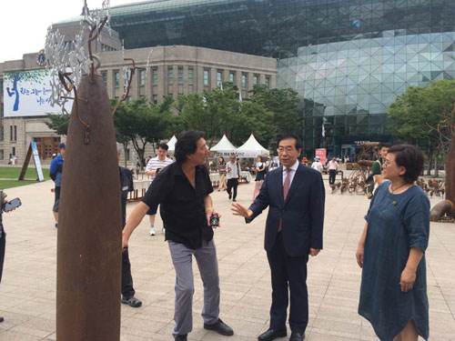 김운성 작가가 매향리 미공군 폭격연습장에서 수거한 폭탄으로 만든 작품에 관해 박원순 서울시장에게 설명하고 있다.