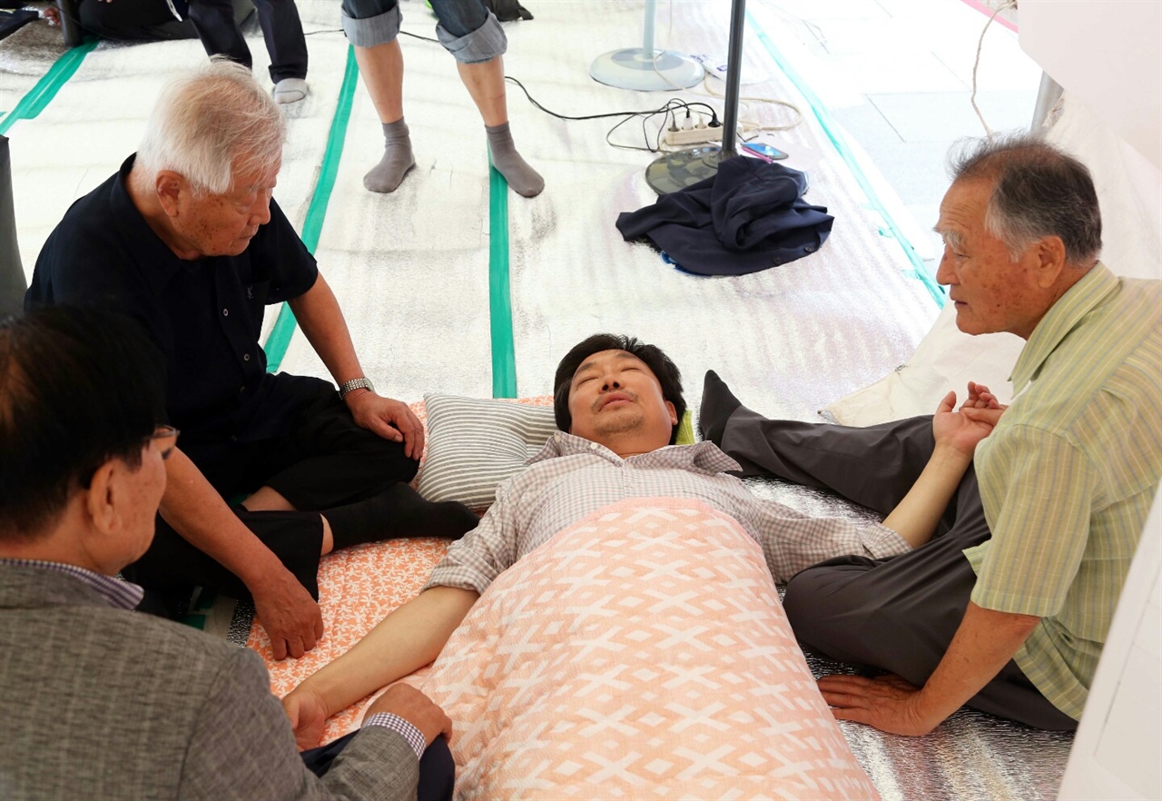 단식농성 5일차, 김홍장 당진시장이 육체적인 고통을 호소하며 지지방문을 온 사람들 곁에 누워있다. 