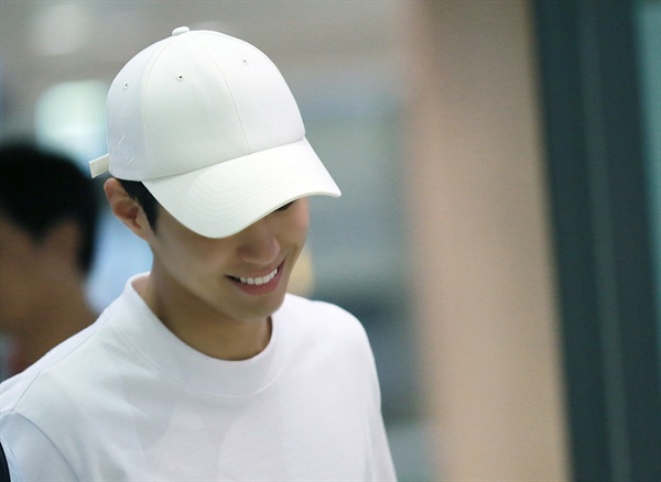  배우 박보검이 입국장안으로 들어서며 밝게 웃고 있다.
