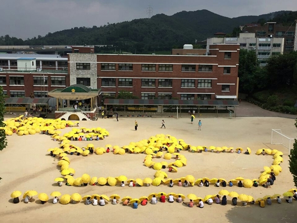 안산초등학교 학생들이 노란우산을 들고 세월호를 추모하는 행사를 가졌다