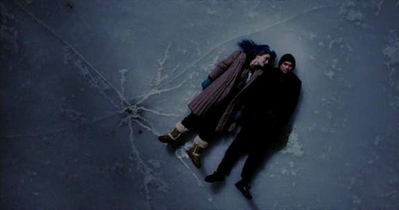 영화 <이터널 선샤인> 스틸컷 얼어붙은 호수에 누워있는 클레멘타인과 조엘