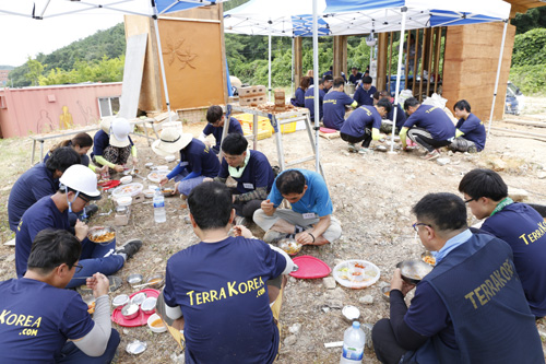 목포대학교에서 열린 흙건축 여름 캠프 참가자들이 현장에 주저앉아서 점심을 먹고 있다. 지난 7월 27일이다.