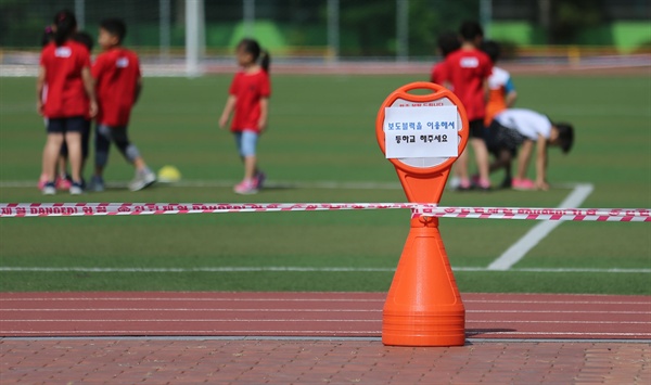 지난 6월 1일 서울 동대문구 한 초등학교 운동장에 유해성 물질이 검출된 우레탄 트랙을 밟지 말라는 안내 문구와 함께 통제 라인이 설치되어 있는 모습.