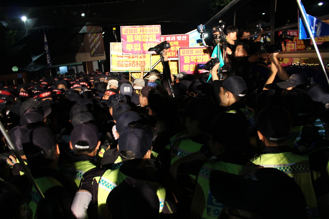 7월31일 밤 9시45분경 갑을오토텍 야간문화제에 참석하기 위해 노동자 가족과 연대하러온 이들이 공장으로 가려하자 경찰이 진입로에서 원천봉쇄하고 있다.