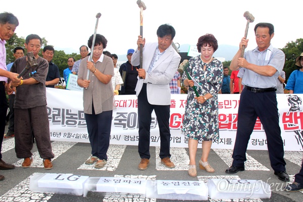  '대기업의 농업진출 저지를 위한 경남대책위'가 4일 오전 경남도청 정문 앞에서 기자회견을 열었는데, 참가자들이 얼음 위에 '엘지, 농업파괴, 농업진출'이라 적은 종이를 올려놓고 망치로 박살내고 있다.