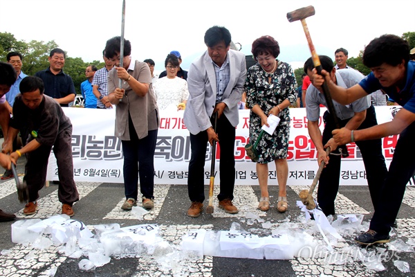  '대기업의 농업진출 저지를 위한 경남대책위'가 4일 오전 경남도청 정문 앞에서 기자회견을 열었는데, 참가자들이 얼음 위에 '엘지, 농업파괴, 농업진출'이라 적은 종이를 올려놓고 망치로 박살내고 있다.