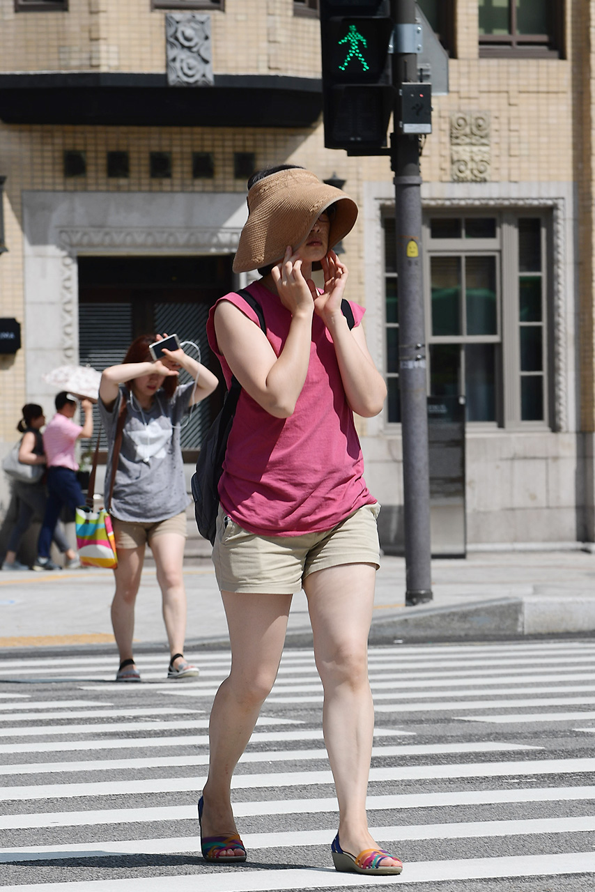  서울지역에 올들어 처음으로 폭염경보가 내려진 4일 오후, 시민들이 모자를 눌러쓴채 얼굴에 내리쬐는 강한 햇빛을 가리고 있다.