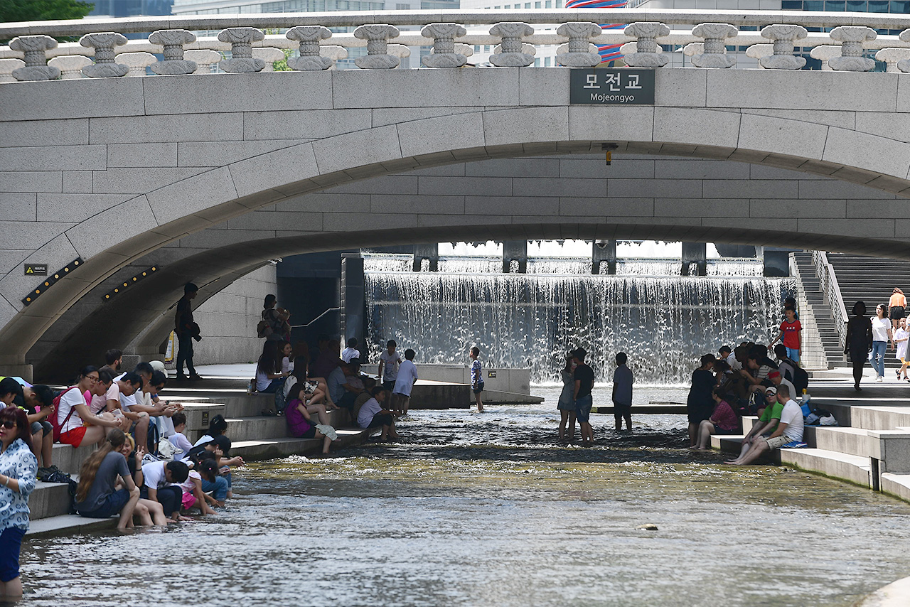  서울지역에 올들어 처음으로 폭염경보가 내려진 4일 오후, 외국인 관광객들을 비롯한 시민들이 청계천 모전교 밑에서 더위를 식히고 있다.