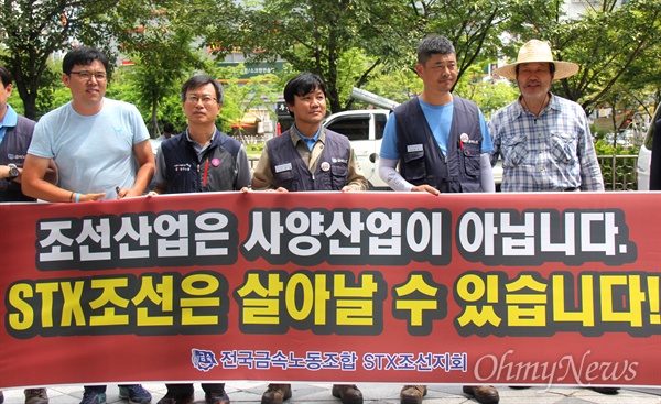 '경청투어'하고 있는 김무성 전 새누리당 대표가 5일 오후 창원고용복지센터를 방문해, 소식을 듣고 찾아온 조선소 노동자들이 펼침막을 들고 있자 함께 서 있기도 했다. 
