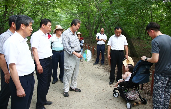 ‘경청투어’를 하고 있는 김무성 전 새누리당 대표가 7일 고향인 경남 함양군 상림공원 숲을 걷다가 마주친 아이에게 손부채로 부채질을 해주고 있다.