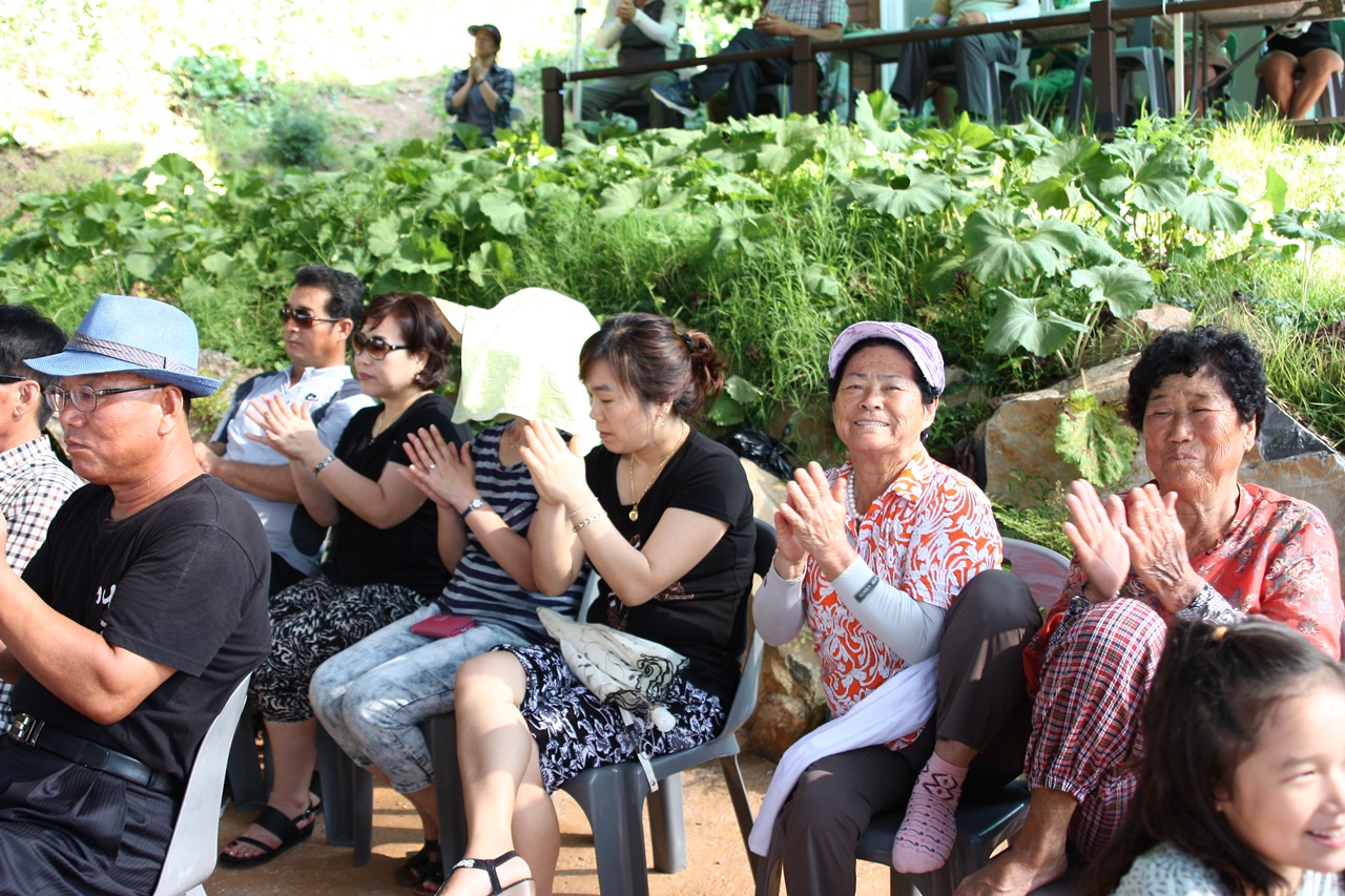 섬마을 오케스트라 공연을 감상하는 마을 어른신들이 기뻐하고 있다.