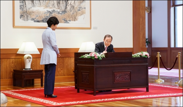 박근혜 대통령이 지켜보는 가운데 청와대에서 반기문 유엔(UN) 사무총장이 방명록을 작성하고 있다