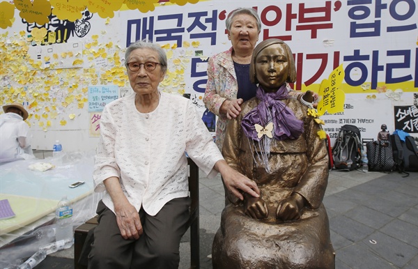 14일 오후 서울 종로구 중학동 주한 일본대사관 앞에서 '세계 일본군 위안부 기림일'을 맞아 열린 '나비 문화제'에 참석한 김복동 할머니가 소녀상 옆 빈 의자에 앉아있다. 오른쪽은 길원옥 할머니.
