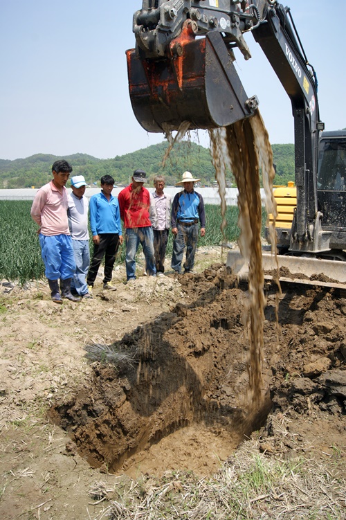 합천보 담수 이후 농지 침수 피해를 호소하는 연리들의 농민들. 포크레인으로 땅을 파자 1미터도 안 돼서 물이 줄줄 올라온다.