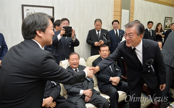 안철수 국민의당 전 대표(왼쪽)와 문재인 전 더불어민주당 대표가 18일 서울 동작동 국립서울현충원 현충관에서 열린 '김대중 전 대통령 서거 7주기 추도식'에 앞서 악수하고 있다.