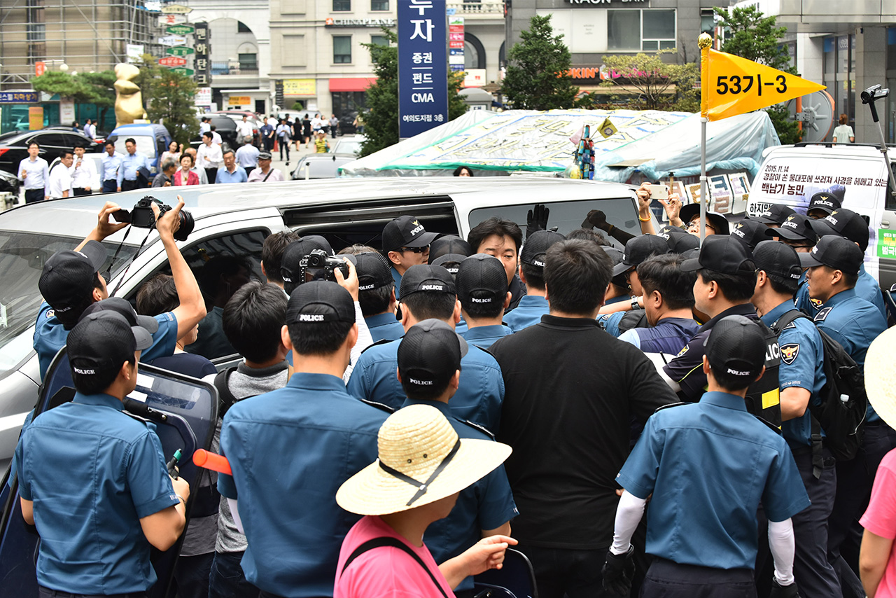 경찰이 18일 저녁 서울 영등포구 여의도 새누리당사 앞에서 개최예정인 '부상 농민 국가폭력 청문회 방해 새누리당 규탄 집회'에 사용될 무대 설치 물품 반입을 저지하며 기자회견 참석자들과 몸싸움을 벌이고 있다.