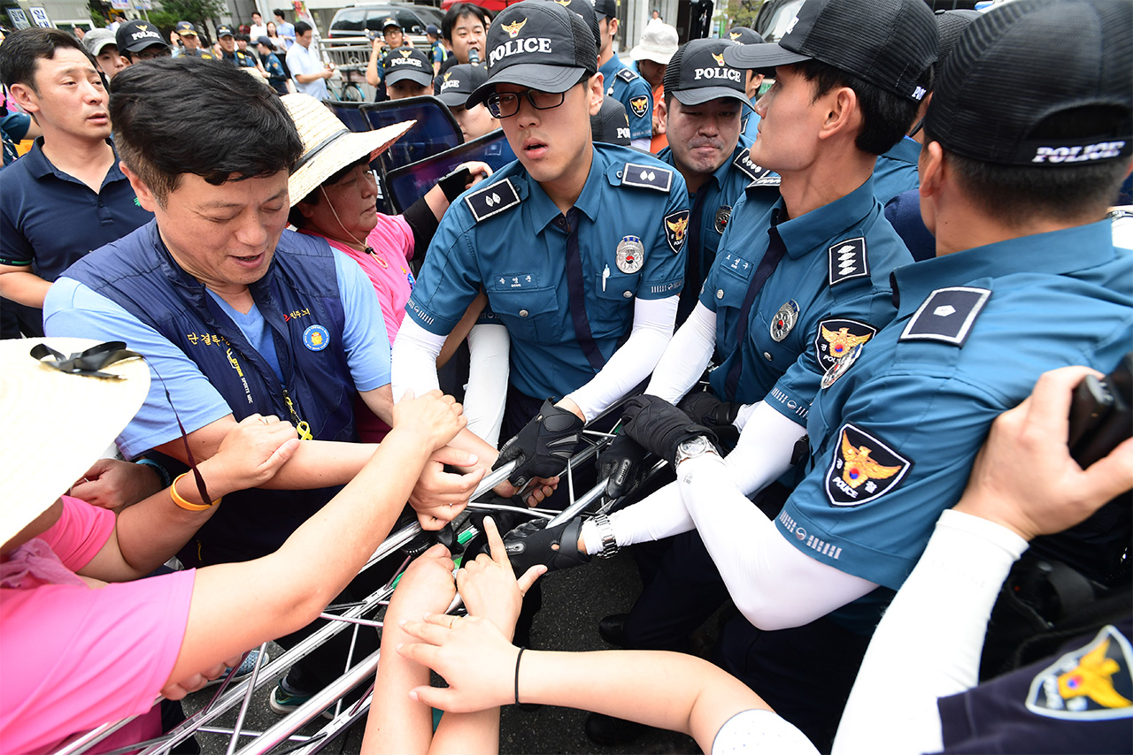 경찰이 18일 저녁 서울 영등포구 여의도 새누리당사 앞에서 개최예정인 '부상 농민 국가폭력 청문회 방해 새누리당 규탄 집회'에 사용될 무대 설치 물품 반입을 저지하며 기자회견 참석자들과 몸싸움을 벌이고 있다.