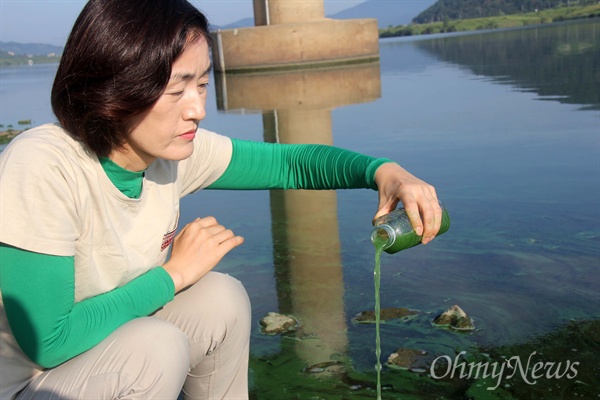 낙동강에 녹조가 창궐하고 있는 가운데, 20일 오전 한은정 창원시의원이 창원지역 수돗물의 원수인 본포취수장 부근에서 걸쭉한 물을 통에 담아 부어보고 있다.