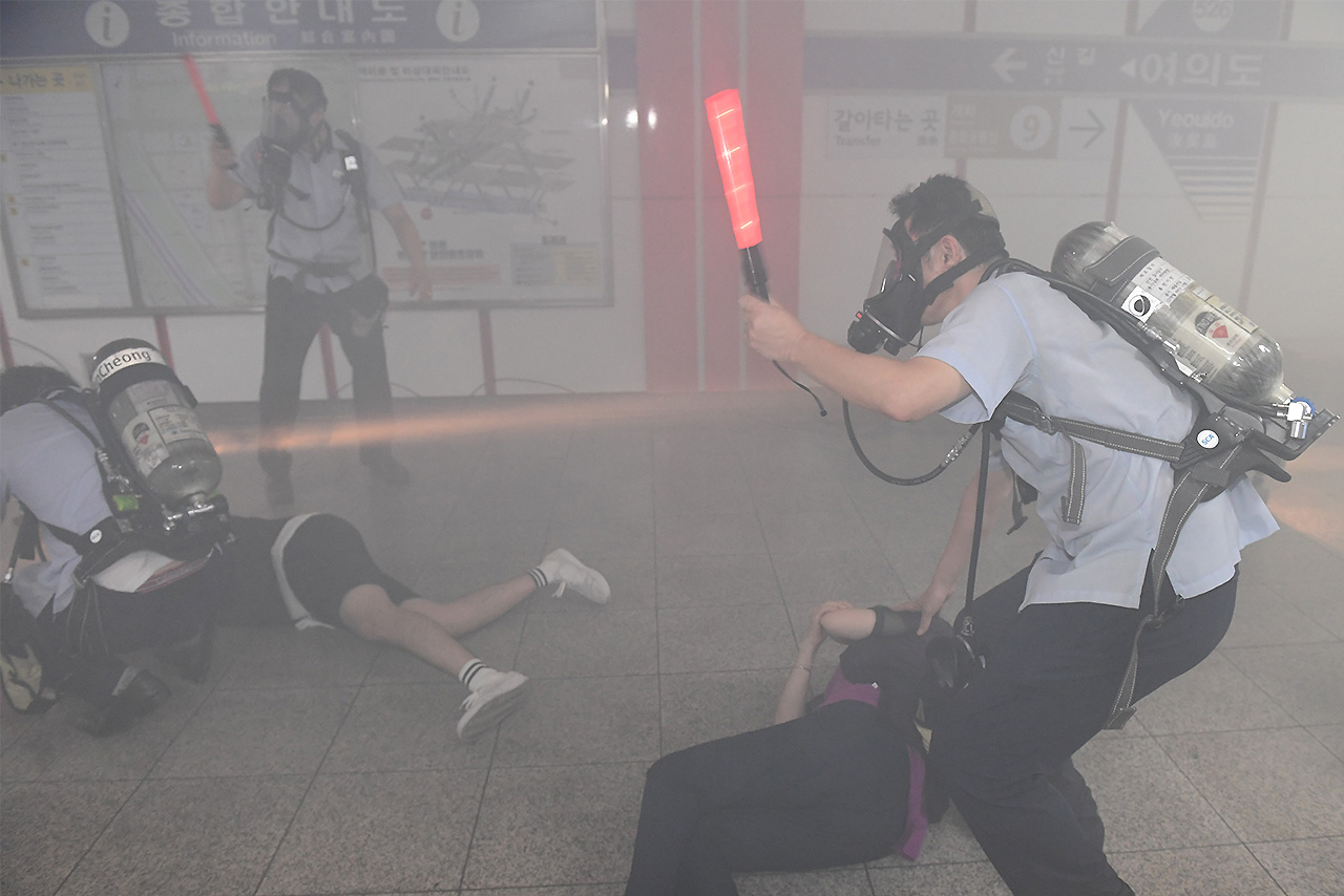 23일 오후 2시부터 서울 영등포구 여의도역에서 실시된 ‘2016 을지훈련 지하철 테러대응 실제훈련’중 지하철역 승무원들이 폭발테러에 의해 쓰러진 시민들을 살펴보고 있다.