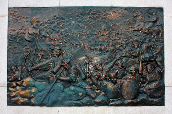 권율 장군 동상 뒤 석조 울타리에 새겨져 있는 행주대첩 당시 관군의 전투 모습을 그린 부조
