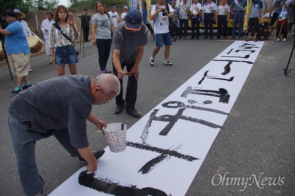 성주 군민들이 27일 오후 성산포대에서 성주군청까지 인간띠잇기 행사를 가진 가운데 행사에 앞서 '사드 가고 평화 오라'는 글귀를 쓰고 있다.