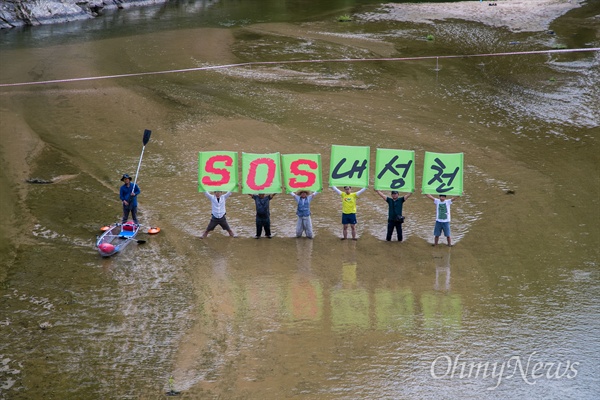  <오마이뉴스> 10만인클럽, 불교환경연대, 환경운동연합, 대한하천학회 회원들이 27일 오후 경북 예천 내성천 일대에서 강 보존을 위해 ‘SOS내성천’이 적힌 피켓을 들고 강 위에 서 있다.