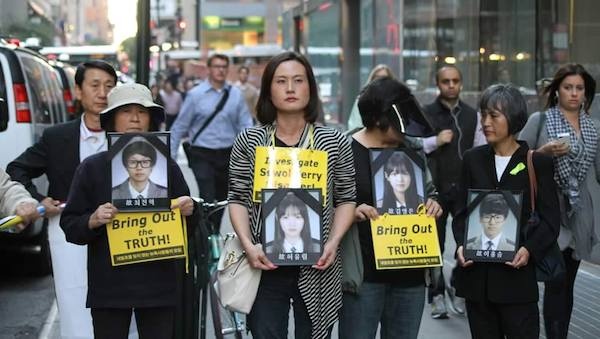 뉴욕 맨하탄에서 세월호 참사 희생자들의 영정사진을 들고 행진하는 린다 리씨(가운데)의 모습.