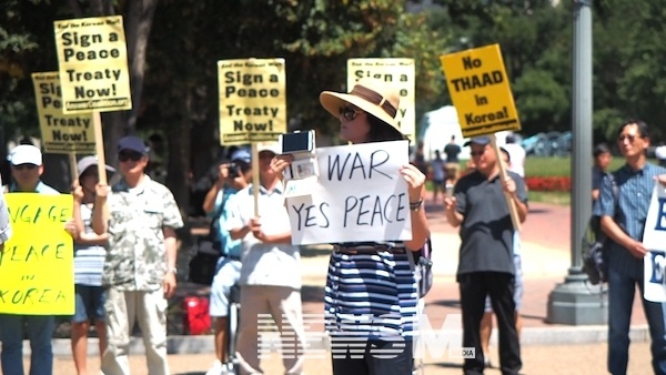 '사드 가고, 평화 오라' 백악관 앞 한반도와 세계 평화를 위한 평화행진 중 'No War, Yes Peace'라는 피켓을 들고 있는 린다 리씨. 피켓을 든 손에는 핸드폰이 함께 들려있다. 시위 모습을 생중계하기 위해서였다.