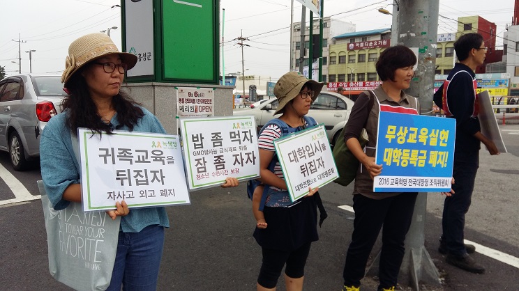 지난 4일 홍성 녹색당 당원들이 홍성 농협 앞에서 피켓시위를 벌이고 있다.