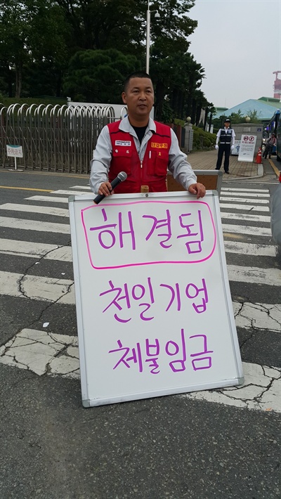  한 달 가까이 체불임금 갈등을 빚은 삼성중공업 사내하청업체 천일기업 노동자들이 회사측과 협상을 벌여 9일 새벽 합의를 이루어냈다. 사진은 김경습 삼성중공업일반노동조합 김경습 위원장이 이날 아침 삼성중공업 거제조선소 앞에서 손팻말을 들고 서 있는 모습.