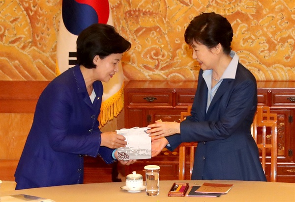 박근혜 대통령이 12일 오후 청와대에서 열린 여야 3당 대표 회동에서 더불어민주당 추미애 대표로부터 선물을 받고 있다.