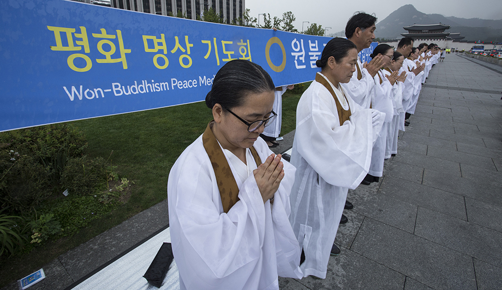 12일 오후 주한미대사관이 보이는 서울 광화문 세종대왕상 앞에서 원불교 교무 및 신도 500여 명이 평화침묵기도회를 열었다. 기도회에 참여한 교무 및 신도들은 굵은 빗줄기에도 미동 없이 자리를 지키며 평화를 염원했다. 