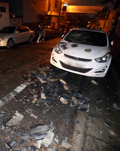 지난 9월 12일 오후 경주에서 발생한 지진으로 울산시 중구의 한 주택 기와가 무너지면서 파편이 주차된 차량 위와 골목 여기저기 떨어져 있다.