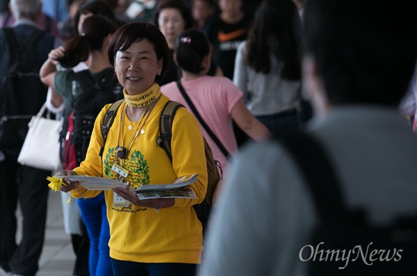  세월호 참사로 아들을 잃은 권미화씨가 13일 오전 서울역 대합실에서 귀성객에게 노란 기억리본을 나눠주고 있다.