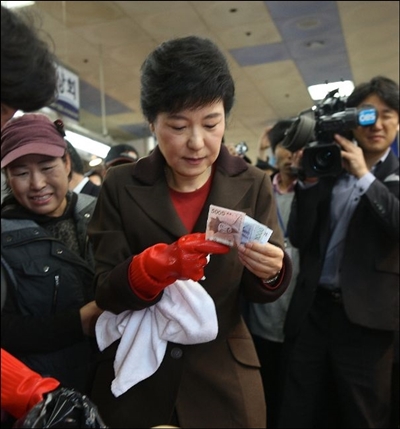 2012년 11월 부산 자갈치 시장을 방문한 박근혜 후보가 8천원을 꺼내는 모습
