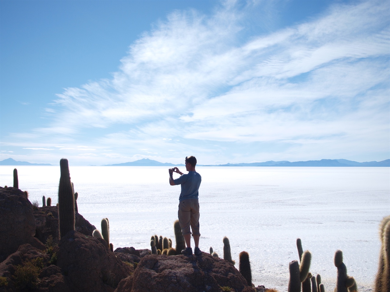 우유니 소금사막 안의 물고기 섬에서 여행자가 사진을 찍고 있다.