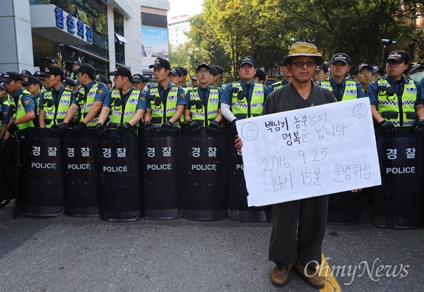 '백남기 농민이 돌아가셨습니다' 백남기 농민 사망 소식이 알려지자 대학로 서울대병원 입구에서 한 시민이 고인의 사망을 알리는 피켓을 들고 있다. 경찰들은 병원으로 들어가는 모든 출입문을 막고 시민들을 통제하고 있다. (2016.9.25)