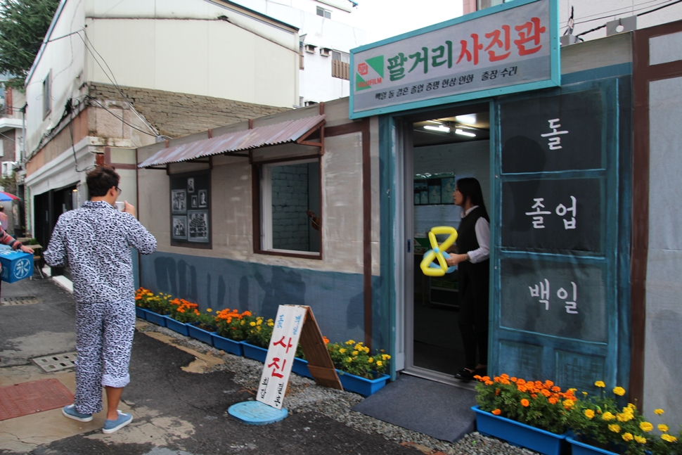 교련복바지 한쪽을 걷어 올린 불량스런 모습의 학생이 길거리에서 차를 마시고 있다. 
