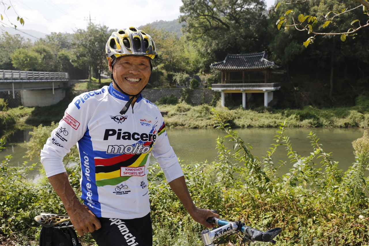 이광섭 씨가 타던 자전거를 잠시 멈추고 환하게 웃고 있다. 지난 9월 27일 마을 앞 겸면천변에서다.