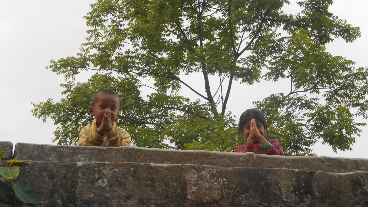 시골 길에서 만난 네팔 아이들. 두 손 모아 인사하며 배시시 웃고 있다.