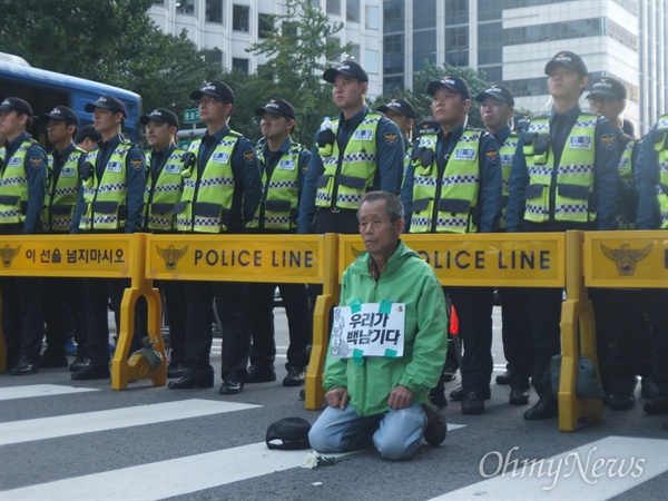 이날 경찰은 병력 71개 부대, 5680여 명을 배치해 만일의 사태에 대비한 것으로 알려졌다. 한 참가자가 경찰 앞에 무릎을 꿇고 앉아 있다.
