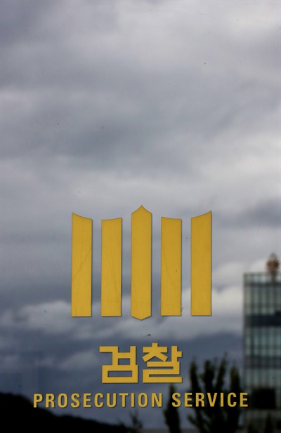 지난 2016년 8월 28일 오후 서울 서초구 서울중앙지검 유리창에 새겨진 검찰 로고가 먹구름에 둘러싸여 있다.