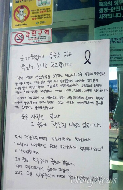 12일 창원시청 앞 시내버스 정류장에 백남기 농민 추모하는 내용의 대자보가 붙어 있다.