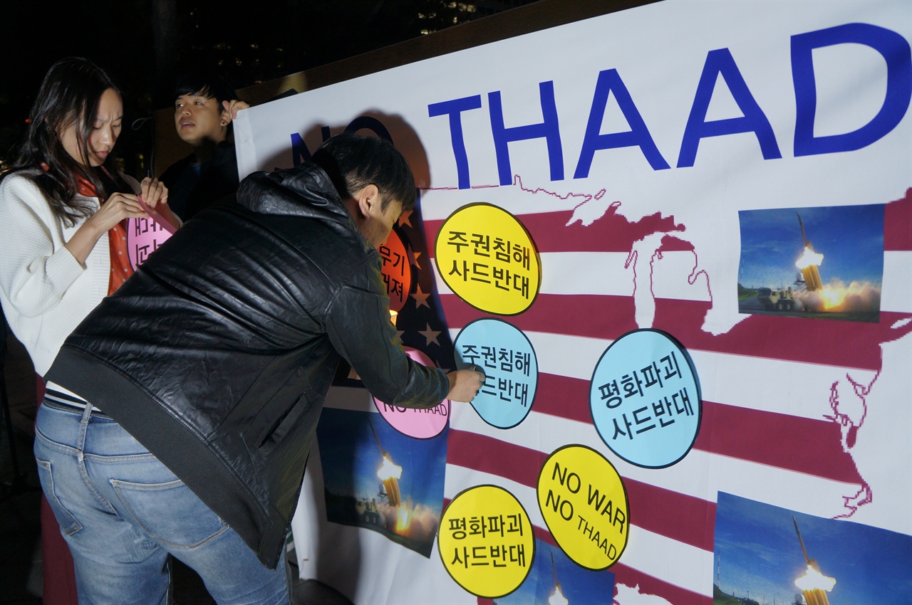 참가자들이 사드가 지키고 있는 미국 본토에 '주권침해 사드반대' '평화파괴 사드반대', NO WAR NO THAAD' '미국무기 사드꺼져' 구호가 적힌 상징물을 붙이고 있다.