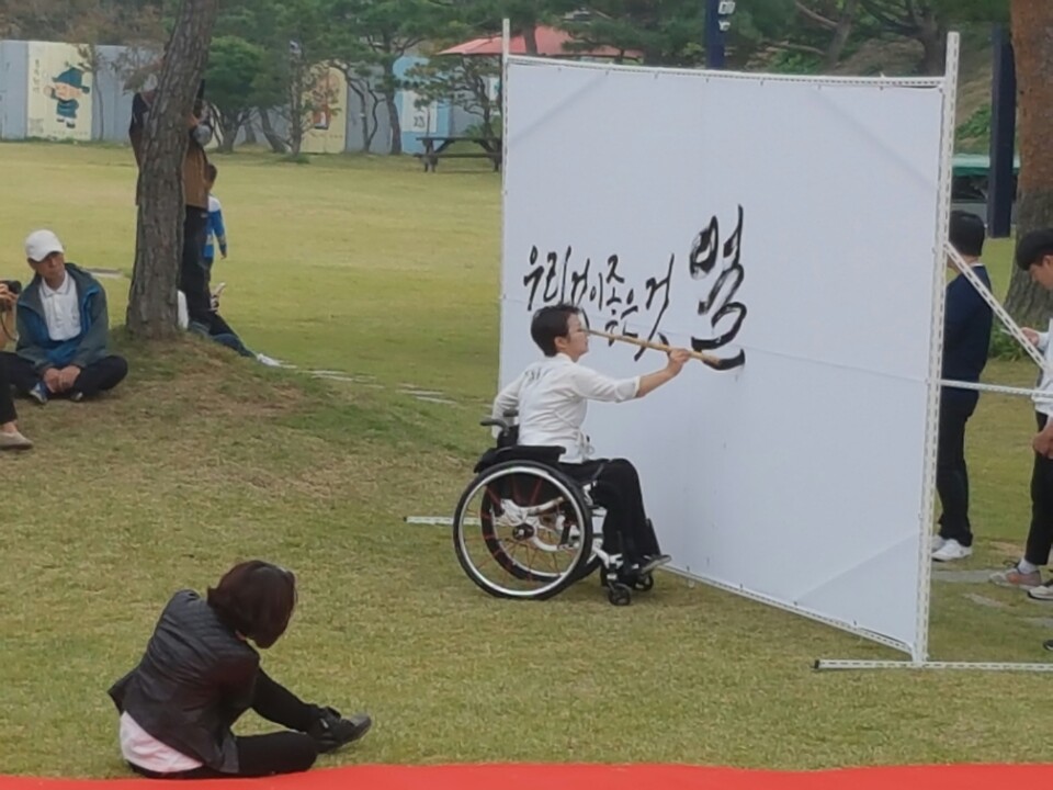 장애앤창의문화예술연대 '잇다'의 이은희 대표가 "우리것 좋은것"이라는 캘리그라피 퍼포먼스를 하고있다