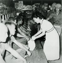 육영수 영부인이 부대를 방문하여 내무반의 사병들에게 위문품을 전달하고 있다(1970. 4.)