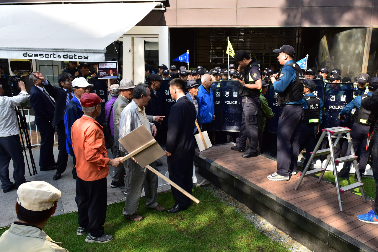 어버이연합 회원들이 18일 오후 서울 중구 세종로 조선일보와 TV조선 건물앞에서 TV조선 '강적들' 의 패널로 출연중인 방송인 김갑수씨의 퇴출을 요구하는 기습 시위를 벌이고 있다.