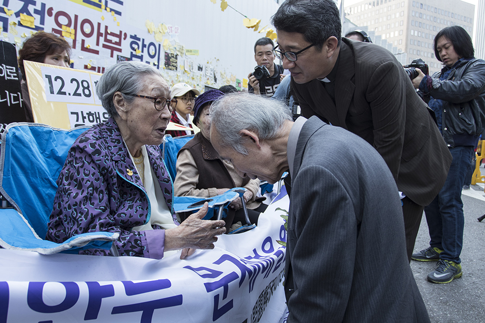  일본인 엔도 토오루 씨가 19일 주한 일본대사관 앞에서 열린 정기 수요시위에 참석해 위안부 피해자인 김복동 할머니 앞에서 무릎 꿇고 사죄의 뜻을 밝혔다. 김복동 할머니는 "일본 국민은 죄가 없다"며 엔도 씨를 달랬다. 