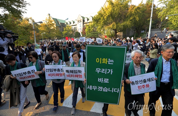 행진 선두에 선 이화여대 교수들 미래라이프대 설립과 '비선실세' 최순실 딸 부정입학 및 학사특혜 관련 논란으로 사퇴요구를 받아온 이화여대 최경희 총장이 19일 오후 교수들의 대규모 사퇴 촉구 기자회견 직전 전격 사퇴를 발표했다. 최 총장의 사퇴 발표에도 불구하고 교수들은 서대문구 이화여대 본관앞에 모여 예정된 기자회견을 열어 입장을 발표한 뒤 학생들과 함께 교내행진을 하고 있다.