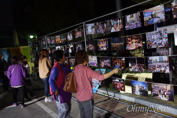 사드 배치 철회를 요구하는 성주군민들의 100일째 촛불집회가 20일 진행된 가운데 촛불집회에 나온 주민들이 사진전을 둘러보고 있다.